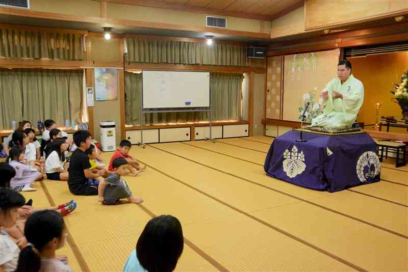 子どもたちに、落語の怪談話を披露した落語家の柳家平和さん＝6日、水俣市