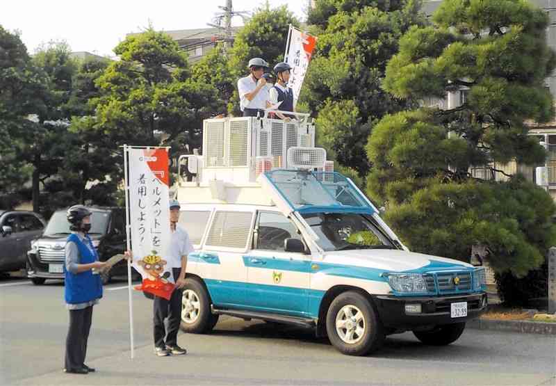 県警と協力し、自転車でのヘルメット着用を呼びかける真和高の生徒ら＝熊本市中央区（熊本市提供）