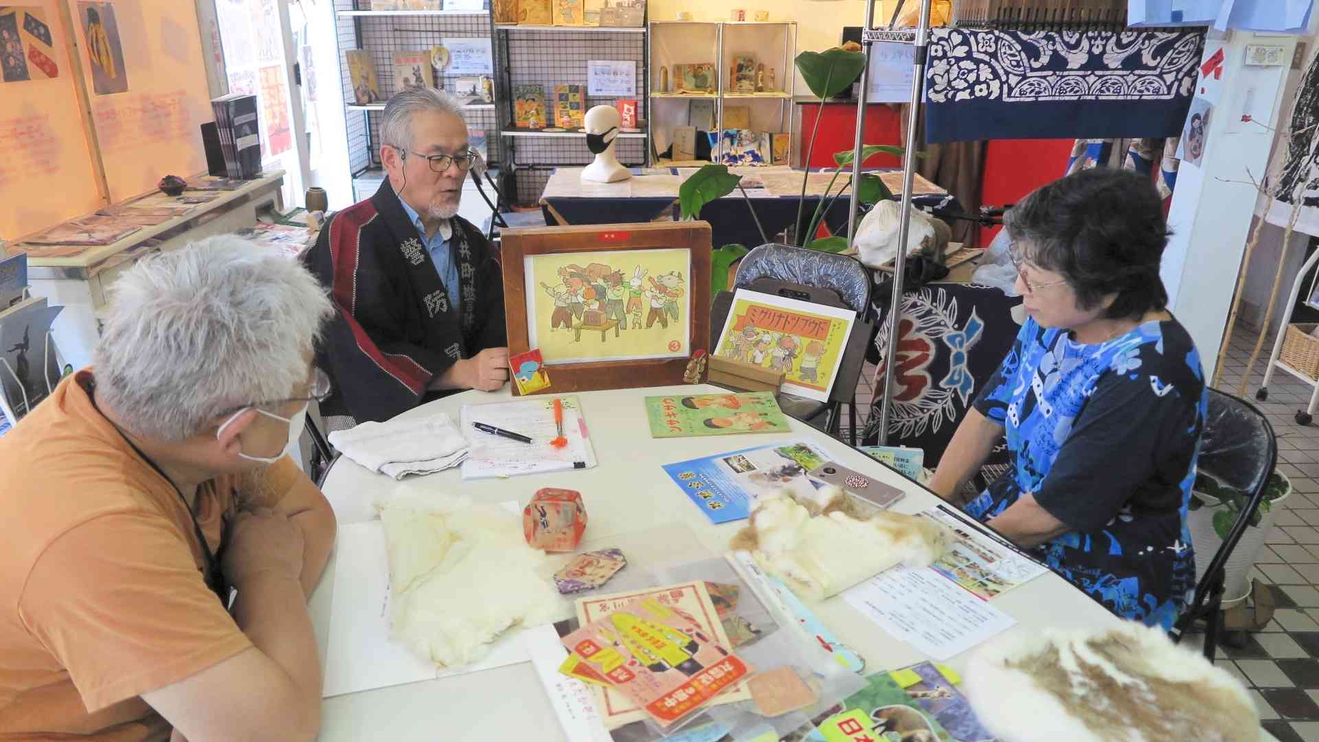 玉名市の「馬空」で紙芝居作りを進める筆者（中央）ら＝2024年8月