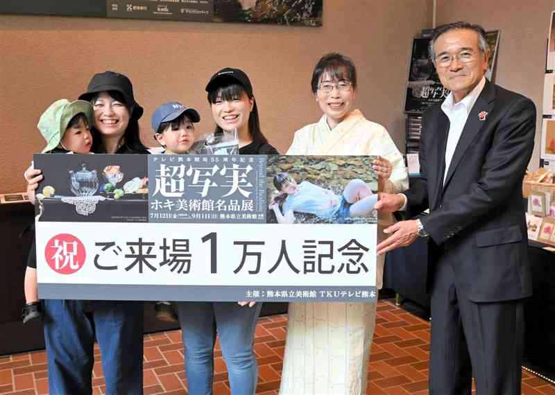 「超写実　ホキ美術館名品展」来場1万人目となった（左から）赤嵜さん親子と明石さん親子＝15日、熊本市中央区