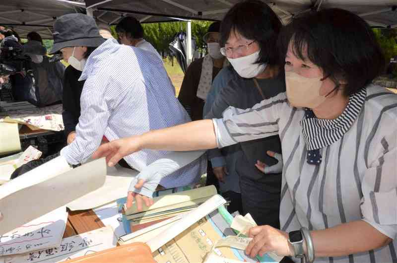 50年前のタイムカプセルを開封し、懐かしい品に顔をほころばせる旧深海小の卒業生ら＝15日、天草市