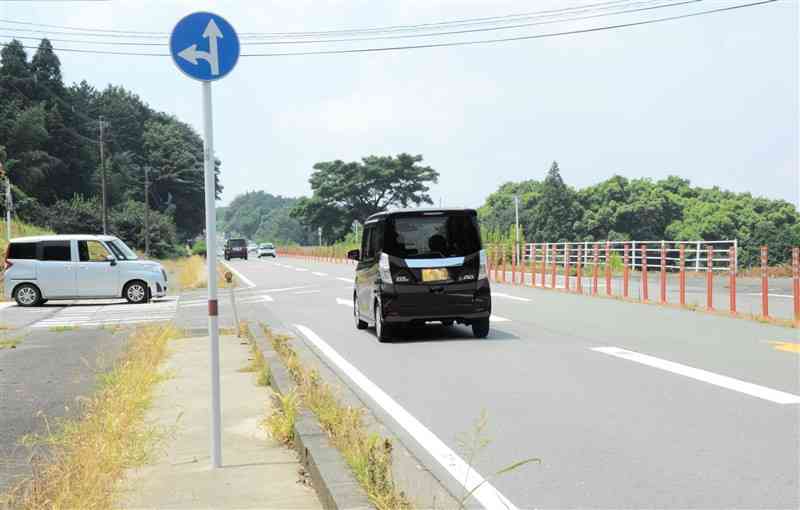 町道（左側）から合流直後のUターンをしないように増設されたオレンジ色のセンターポール＝6日、菊陽町