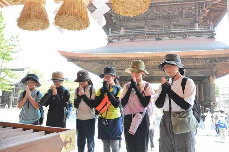 道中の阿蘇神社で無事などを祈る子どもたち＝18日、阿蘇市