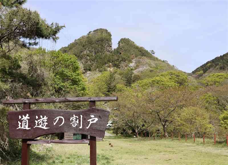 山の一部がえぐれている、（B）にある金山のシンボル＝4月、新潟県の（B）