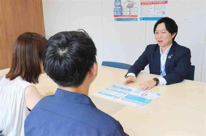 肥後銀行の「ひぎんローンプラザ水道町」で、住宅ローン金利の説明を受ける来店客（手前）＝8月、熊本市中央区