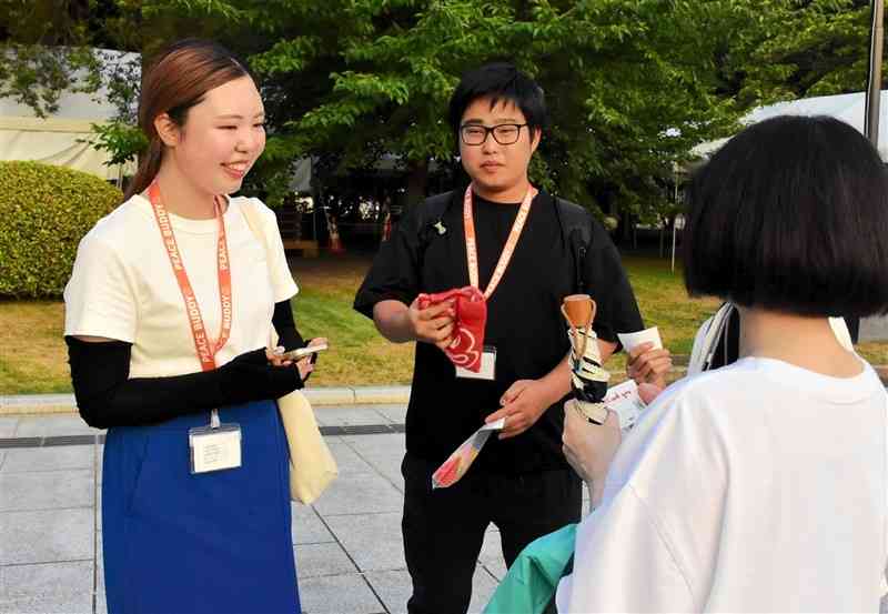 平和公園を訪れた人にインタビューする「ピースバディ」の浅海智絵さん（左）と池田風雅さん＝8月6日、広島市中区