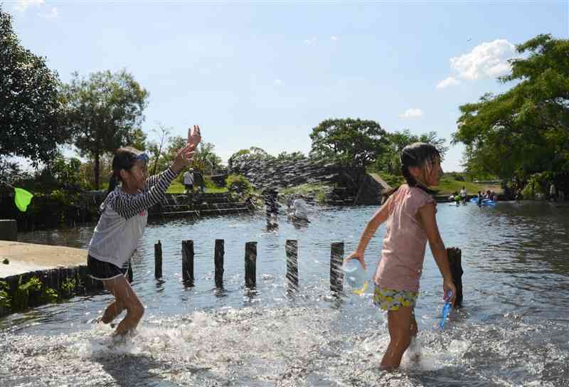 台風10号が通過した後、厳しい暑さが戻り、水前寺江津湖公園で水遊びする子どもたち＝8月31日、熊本市中央区