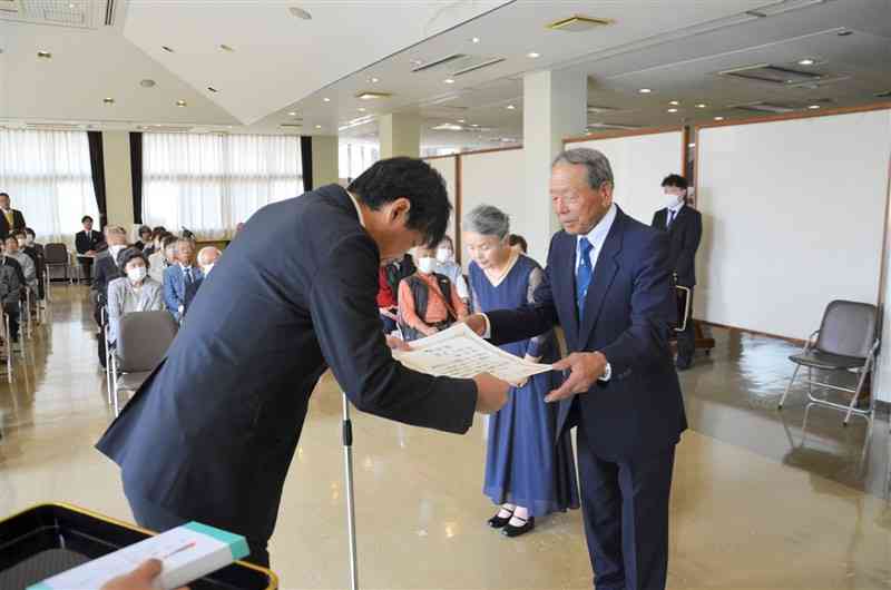 金婚夫婦の表彰状を受け取る池田一吉さん（右）と妻の幸代さん＝3日、長洲町