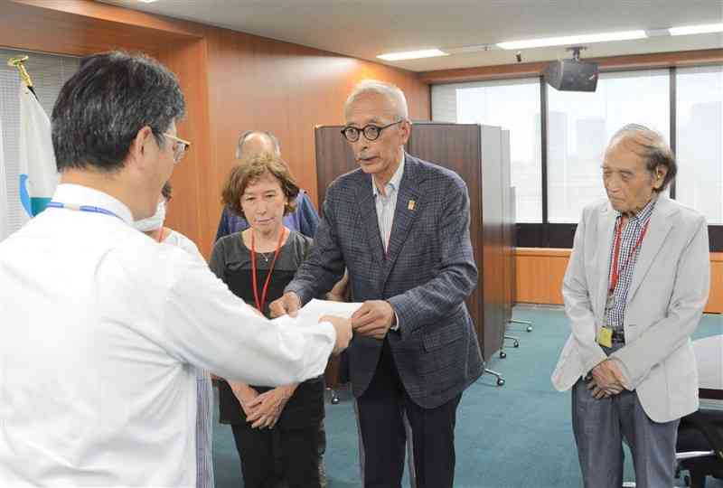 環境省の前田光哉環境保健部長（左）に要望書を手渡す芥川仁代表理事＝3日、東京・霞が関