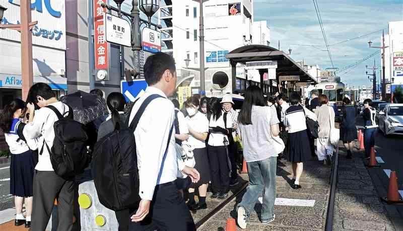 通勤や通学客で混み合う朝の熊本市電健軍町電停＝7月中旬、熊本市東区（上村彩綾）