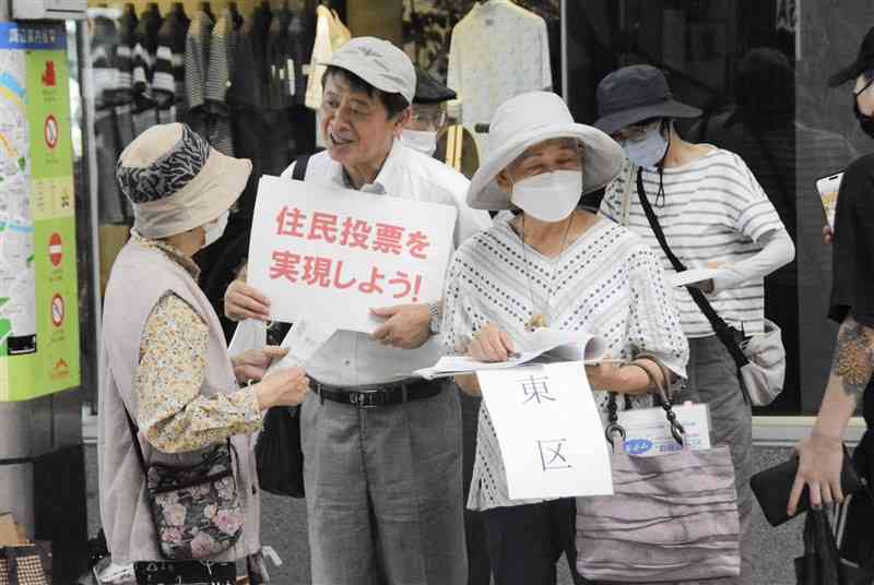 住民投票条例の制定に向け、市民に署名への協力を呼びかける市民団体のメンバーら＝11日、熊本市中央区