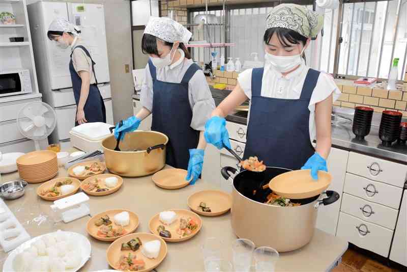 朝食を皿に盛り付ける熊本県立大の学生＝11日、熊本市東区