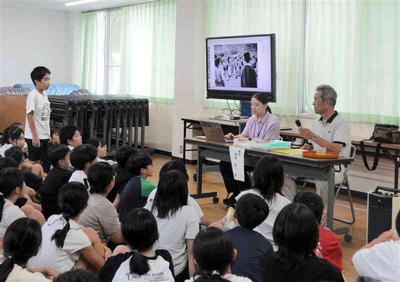 戦争について学ぶ授業で、講師の豊崎晃一さんに質問する隈庄小6年の児童＝10日、熊本市南区