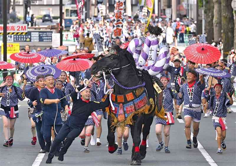 勢子のかけ声とともに、勇壮に披露された「馬追い」＝16日午前、熊本市中央区の日銀熊本支店前（上杉勇太）