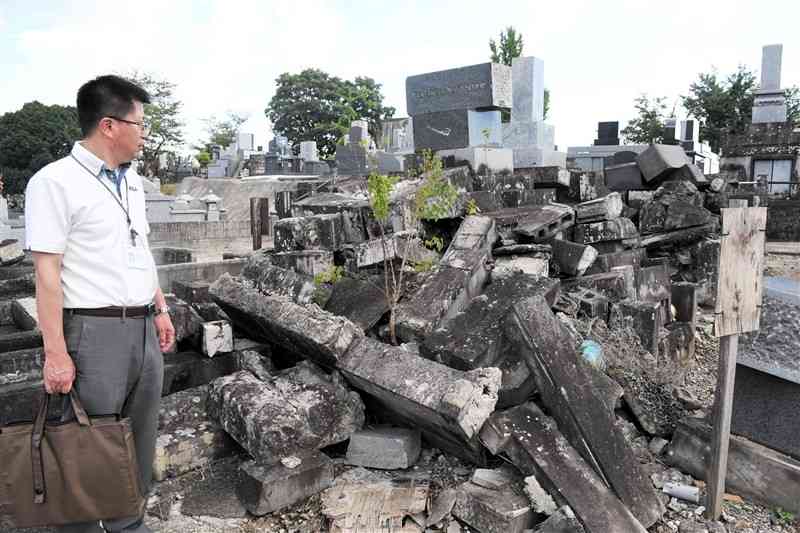 熊本市営小峯墓地で無縁墓を確認する市職員＝12日、熊本市中央区