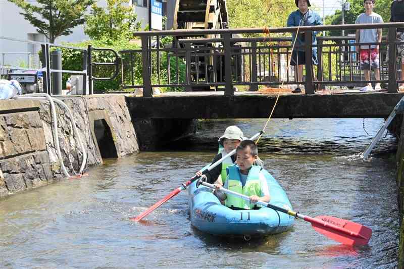 イベント準備のため、築地井手でボートに乗る子どもたち＝1日、菊池市