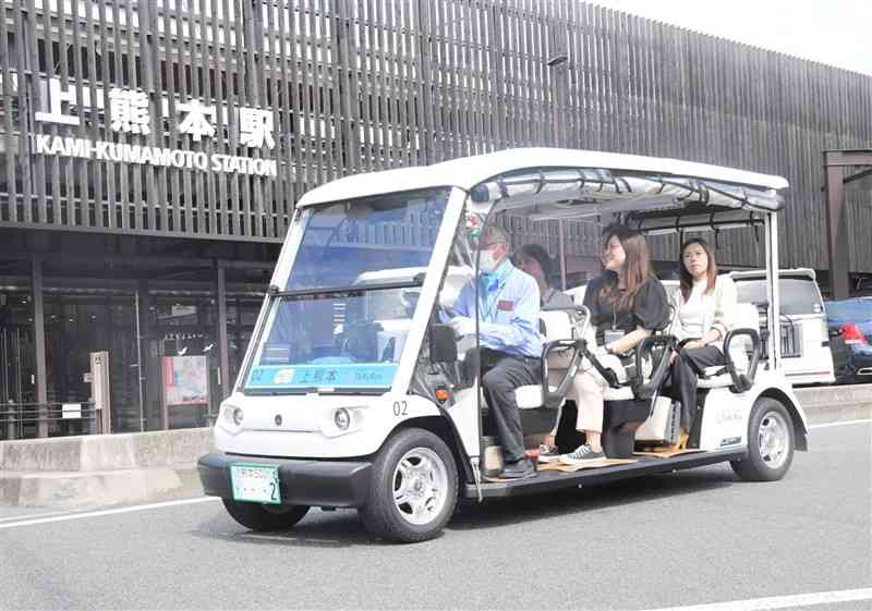 運行が始まった県内民間初のデマンド型乗り合いタクシーに試乗する関係者ら＝20日、熊本市西区