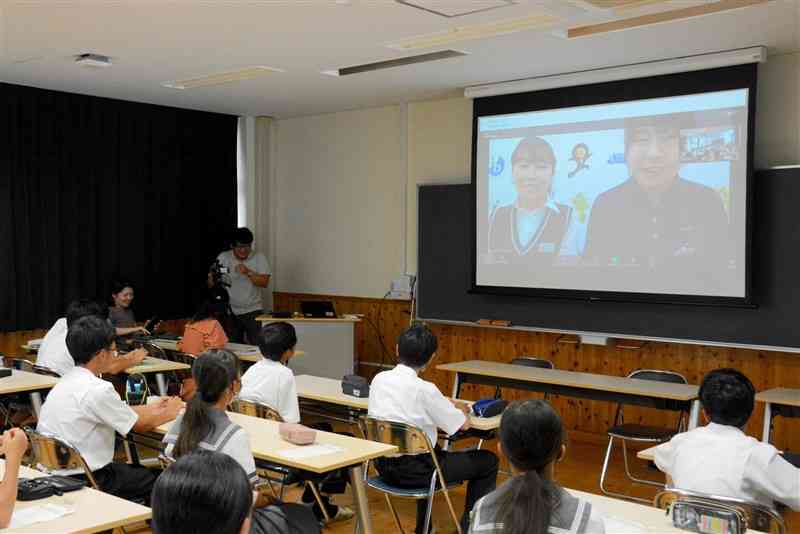 大宮国際中等教育学校の5年生（奥）から国際バカロレアの特徴を聞く八代中1年生＝20日、八代市