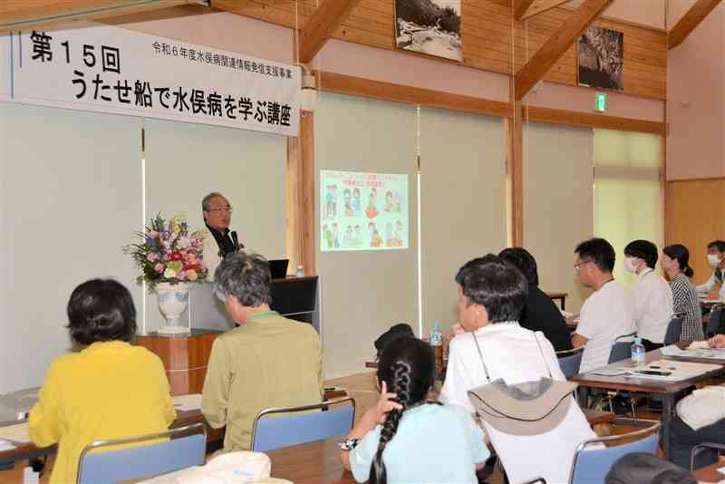 「水俣病事件」について講演する川本愛一郎さんと、耳を傾ける参加者＝21日、芦北町