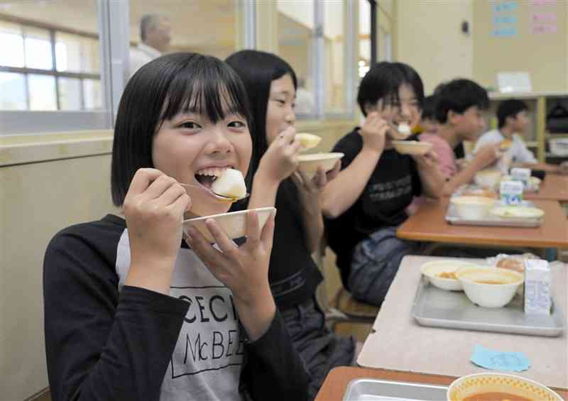 給食に提供された荒尾梨を食べる八幡小の児童たち＝24日、荒尾市