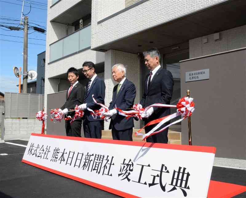 熊本日日新聞社大津総局の竣工式で、テープカットをする河村邦比児会長（右から2人目）と伊豆信太郎社長（同3人目）ら＝25日、大津町