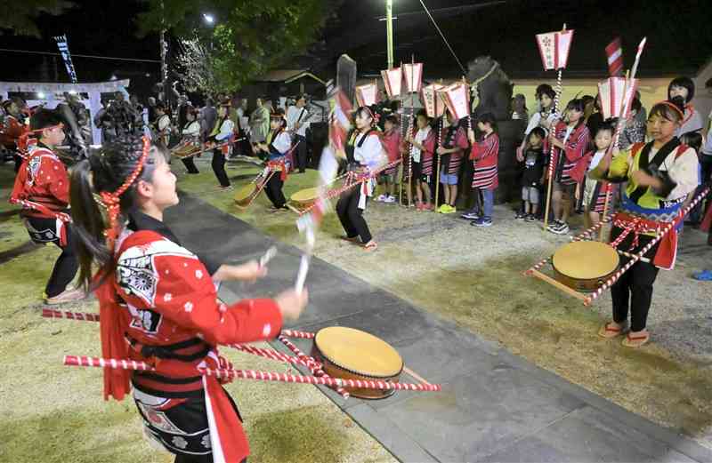 境内で太鼓をたたき、楽を奉納する腹赤小の児童たち＝25日、長洲町