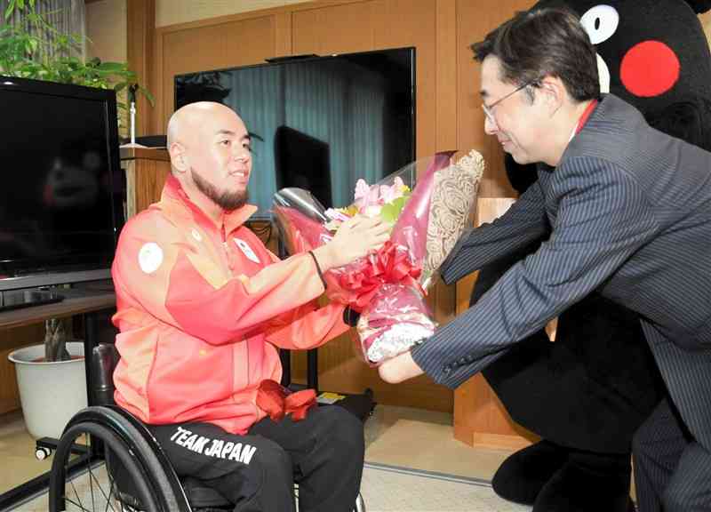 木村敬知事（右）から花束を受け取る乗松聖矢＝27日、熊本県庁