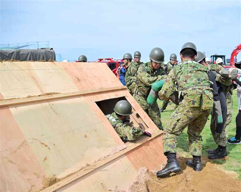 大地震が発生した想定の訓練で、人命救助活動に当たる参加者＝28日、八代市