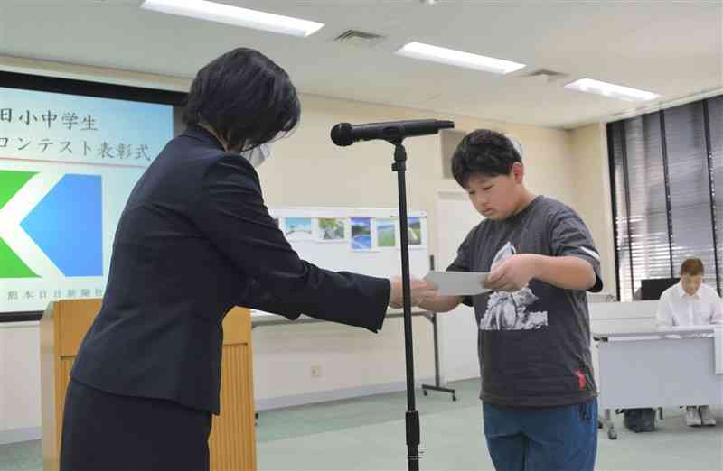 熊日賞の賞状を受け取る橘駿仁さん（右）＝28日、熊本市中央区