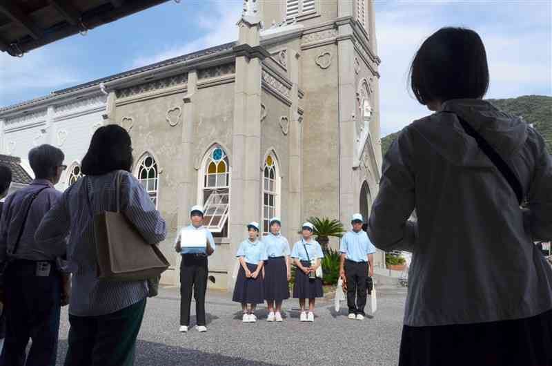 世界遺産「﨑津集落」を案内する河浦中の1年生（奥）＝９月28日、天草市