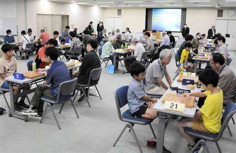 第60回県アマ棋王戦の予選で対局する出場者たち＝29日、熊本市中央区