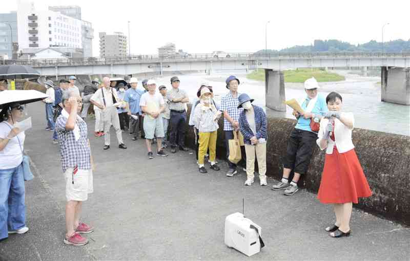 人吉旅館女将の堀尾里美さん（右端）から被災当時の話を聞く参加者たち＝28日、人吉市