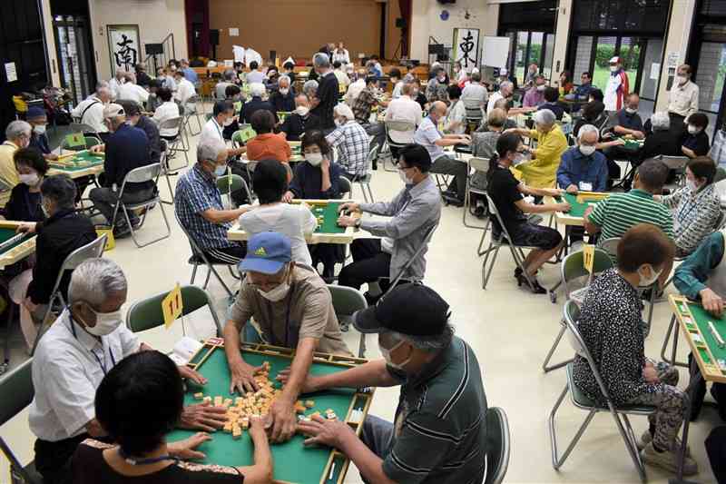 熊本健康マージャン協会主催で毎年開かれている「敬老の日健康マージャン交流大会」。今年も最高齢93歳の男性をはじめ愛好者約90人が参加、日頃の腕を競った＝熊本市中央区の大江公民館、9月22日