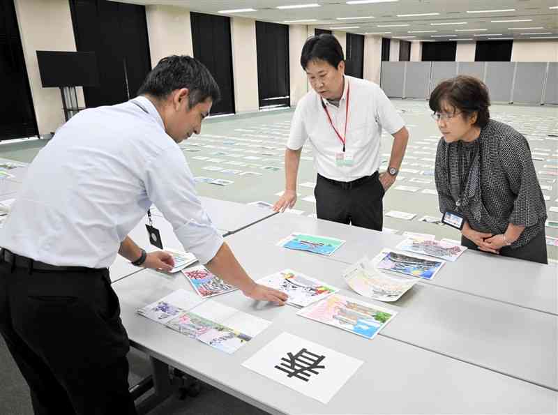 「みんなでつくる　熊本城カレンダー絵コンテスト」の応募作品を見る審査員＝9月26日、熊本市中央区