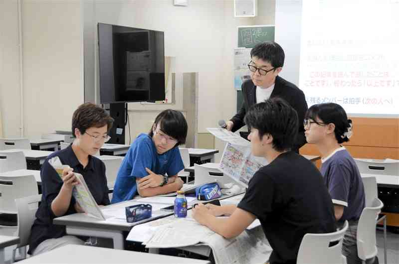 「新聞トークタイム」で、目に留まった新聞記事を発表し合う学生＝1日、熊本市東区