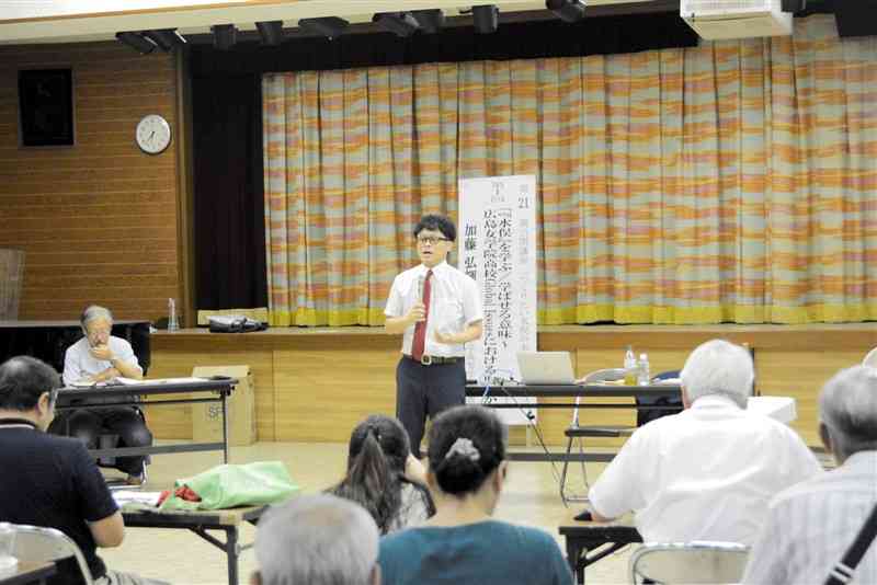 「水俣を学ぶ、学ばせる意味」と題して講演する広島女学院中学高校の加藤弘輝教諭＝1日夜、水俣市