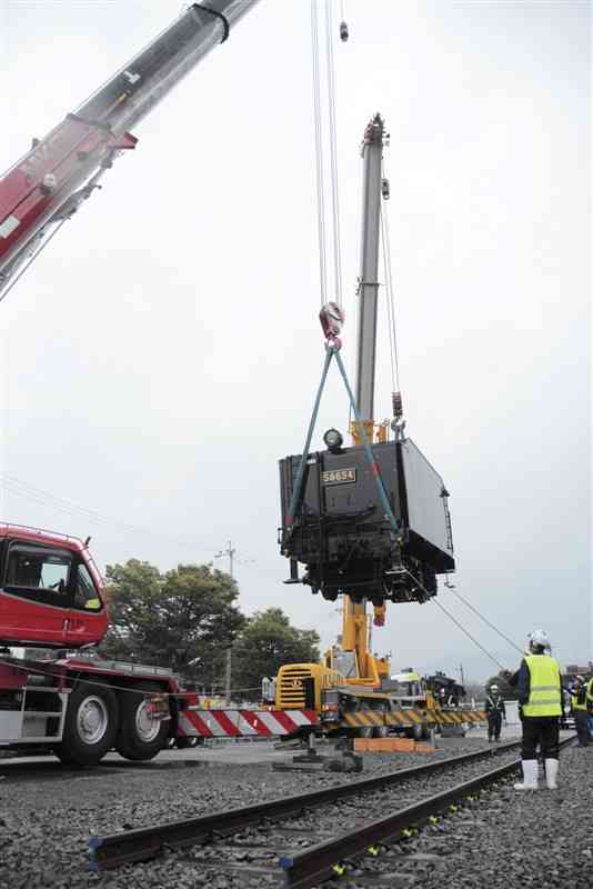 クレーン車で展示用に敷いたレールに降ろされる炭水車部分＝2日、人吉市