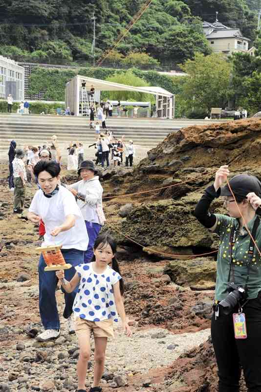 干潮時に赤い糸を弁天島まで引く参加者ら