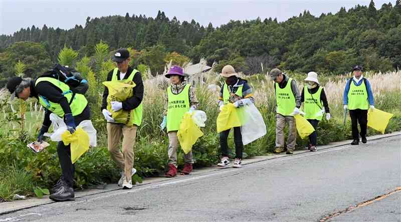 瀬の本高原周辺でごみを拾い集める一斉清掃活動の参加者＝5日、南小国町