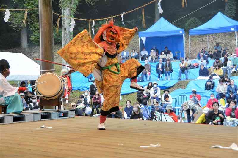 熊本県内外から詰めかけた見物客の前で、神楽を披露する「横堀岩戸神楽保存会」の舞い手＝5日、阿蘇市