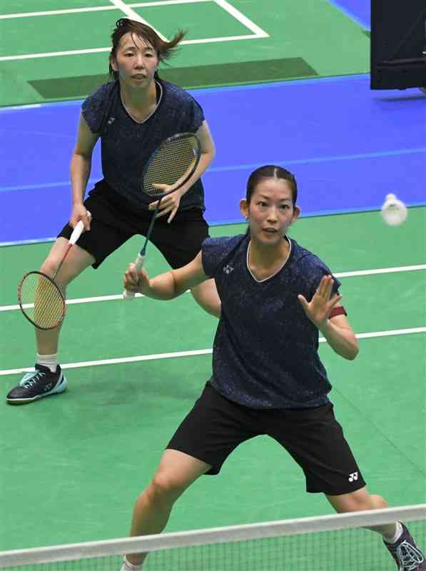 【バドミントン成年女子3回戦・熊本－東京】ダブルスでラリーを繰り広げる熊本（再春館製薬所）の松山（手前）と郡司＝唐津市文化体育館