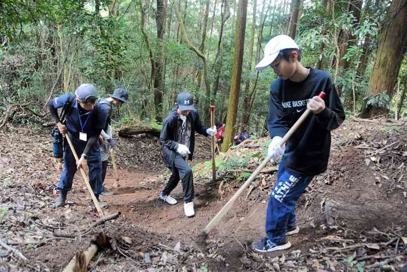 雁回山の登山道「城南コース」の土砂を取り除く参加者ら＝6日、熊本市南区