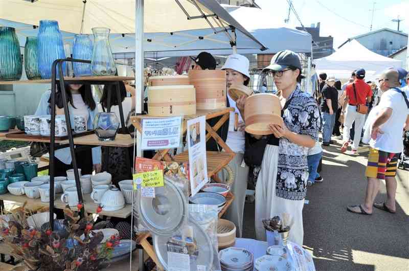 蚤の市で商品を手に取り、品定めする来場者ら＝6日、甲佐町