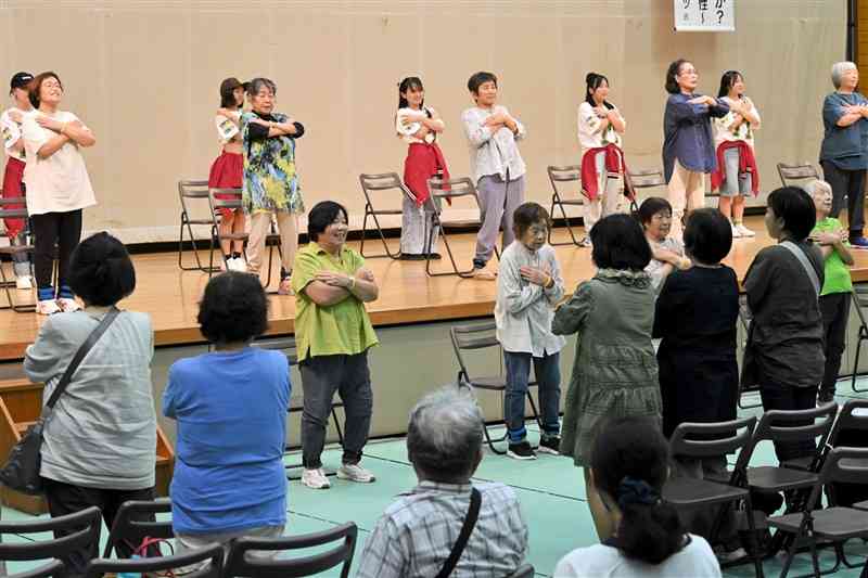 来場者も一緒に体を動かした「いきいき百歳体操」＝6日、山鹿市