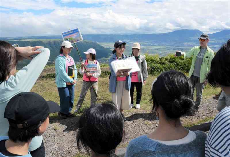 大観峰展望所で観光客らに阿蘇の魅力を伝えるジュニアジオガイド＝6日、阿蘇市