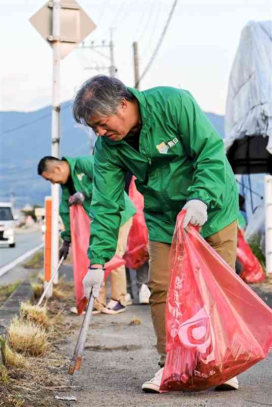 国道沿いの歩道でごみを拾う熊日玉名店主会の店主ら＝10日、玉名市