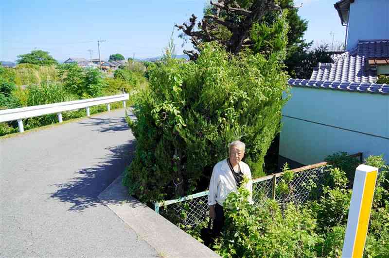 玉名市を相手に本人訴訟を起こした山中博さん。市道が家の庭より高くかさ上げされ、ごみや雨水が流入するようになったという＝玉名市