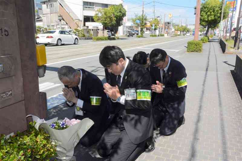 16年前の死亡事故現場で、献花して安全を誓う熊本市交通局の幹部ら＝12日、熊本市西区