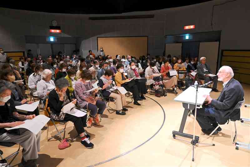 アラン・ローゼン元熊本大教授の朗読に耳を傾ける来場者＝12日、熊本市中央区