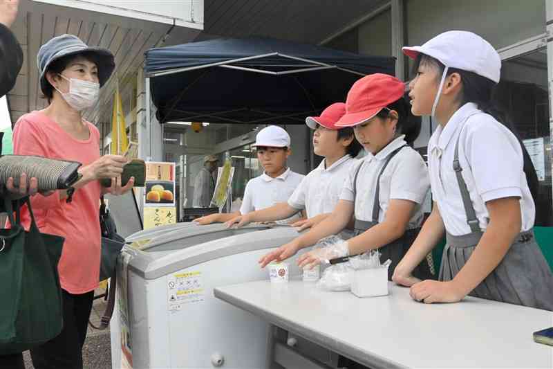 梅シャーベットを元気に販売する泗水西小の児童＝10日、菊池市